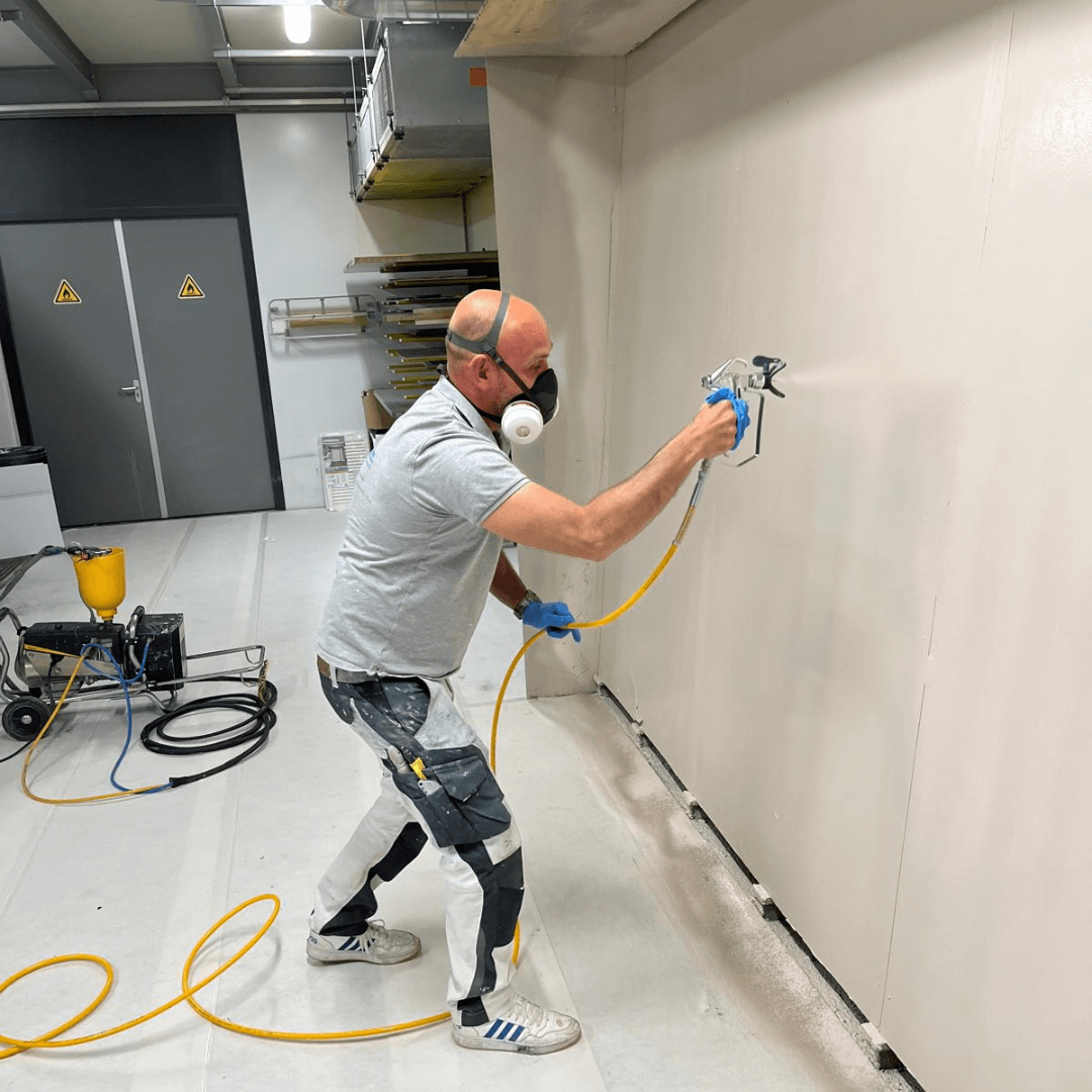 Op de foto staat onze schilder in actie met een verfspuit om wanden glad aftespuiten in elke kleur die u maar wil. zoekwoorden: interieur, ontwerp, advies , stylist, kleur, schilder, binnen, nieuwbouw, woning, verbouwen, renoveren, Amersfoort, Zeist, Soest, heel, Nederland